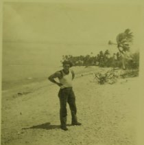 An enlisted man standing on the beach.